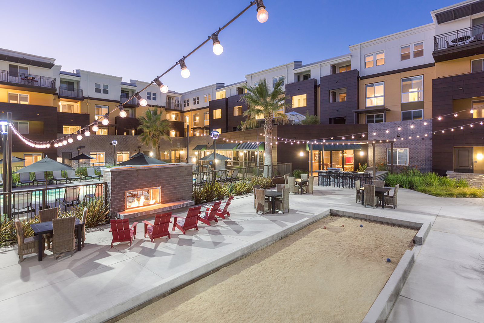 fire pit area with bocce ball court with tables and chairs